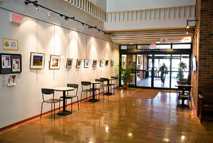 view of the interior lobby of library with cafe tables and artwork on the walls